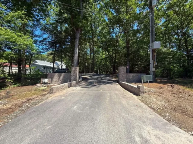 Asphalt driveway approach through the trees