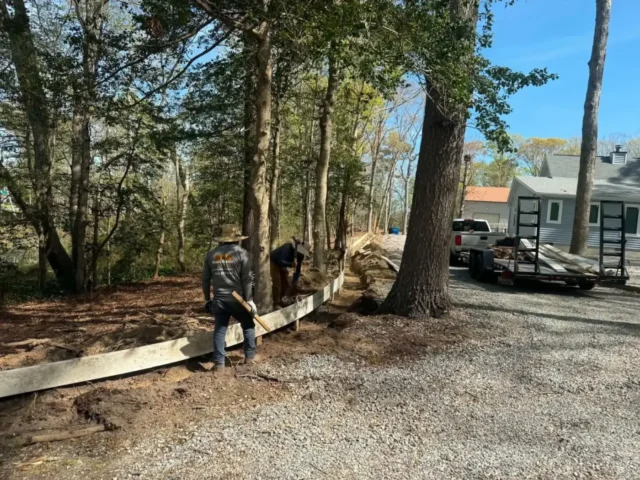 Crew setting timber edging along a gravel drive