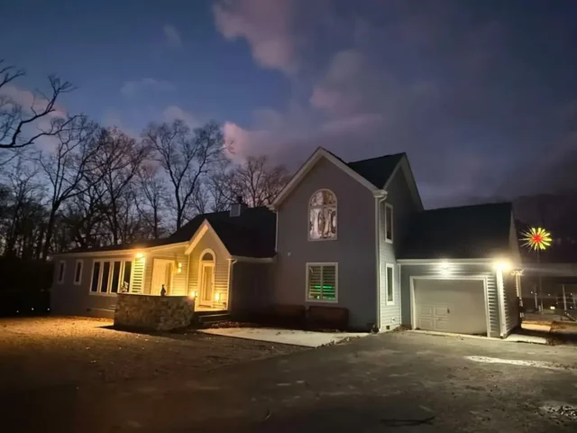 Finished house at dusk with the exterior lights on