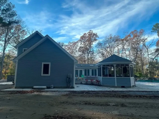 Side of the house with new siding and a screened gazebo