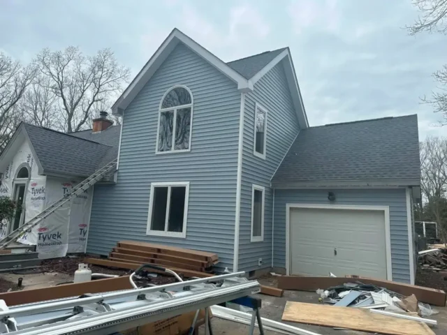 New siding going on, with ladders and trim on site