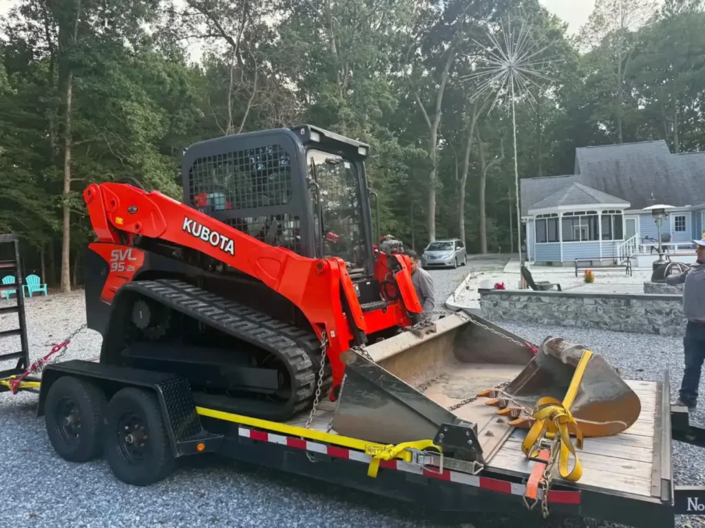 Kubota track loader and bucket loaded on a trailer